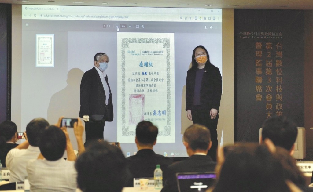 高志明（左）代表「台灣數位科技與政策協進會」，致贈數位發展部部長唐鳯一份透過區塊鏈技術鑄造的「感謝狀NFT」，並一同合照。
