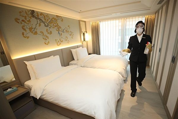Staff member disinfects quarantine hotel room.
