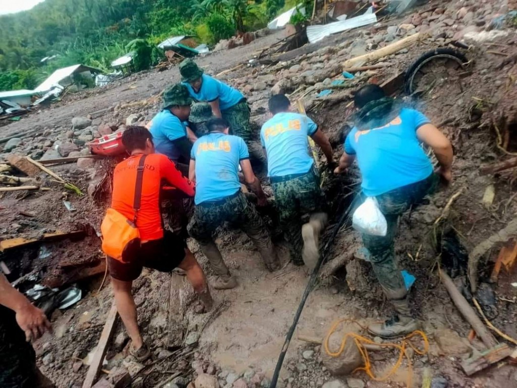 Philippine Coast Guard (PCG) and Philippine National Police (PNP) rescuers retrieve a body following flooding and landslides due to Tropical Storm Nal...