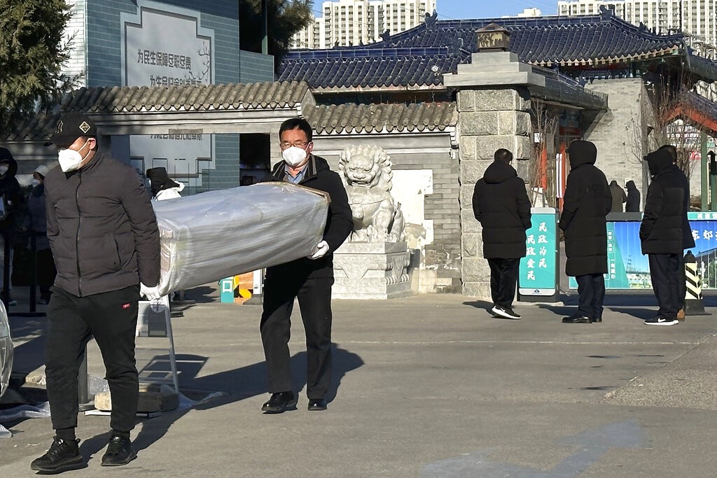 Men carry a casket outside a crematorium in Beijing, Saturday, Dec. 17, 2022. 