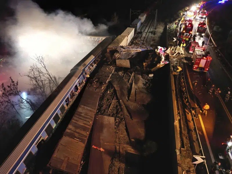 Smoke rises from trains as firefighters and rescuers operate after a collision near Larissa city, Greece, early Wednesday, March 1, 2023. The collisio...