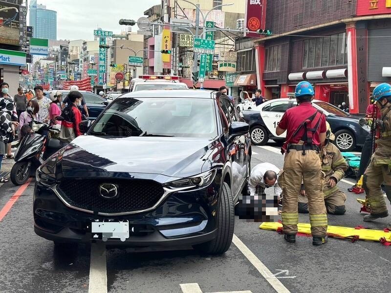 First responders rescue Li from under SUV. (Tainan City Police Department photo)
