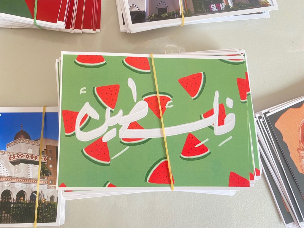西瓜因色彩與巴勒斯坦國旗相當，被作為替身與象徵。圖為台北清真寺在2023年10月22日所舉辦的「與加薩人民站在一起」慈善市集中所販賣的明信...