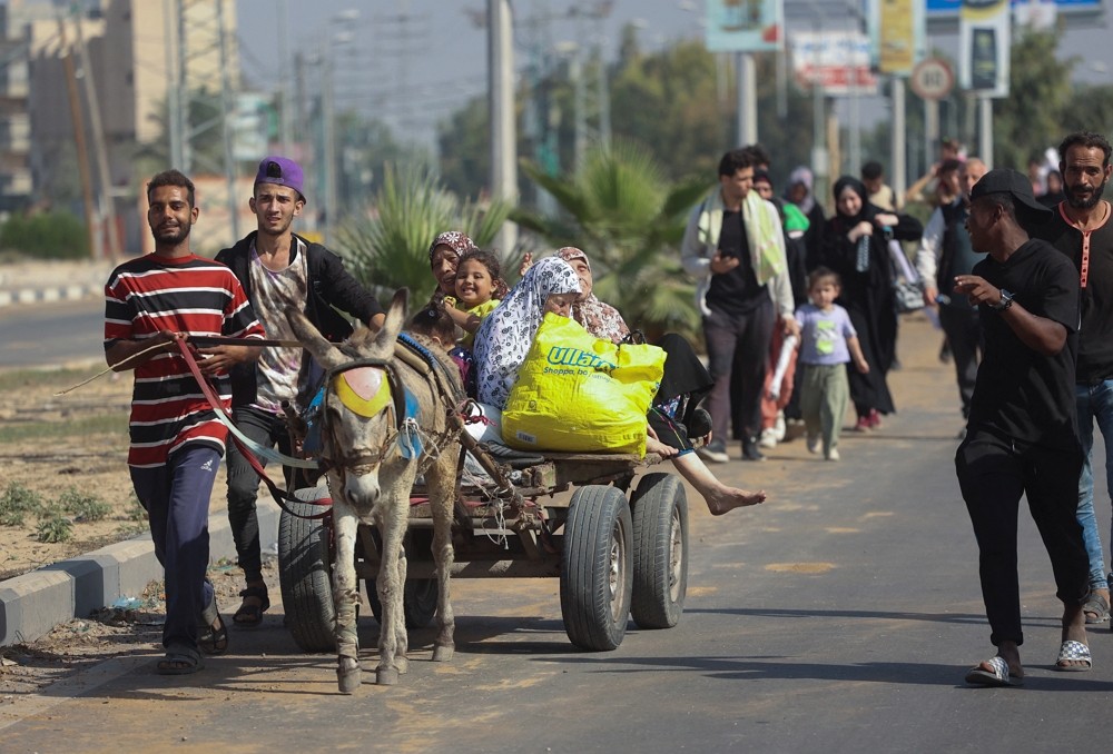 Palestinian civilians ride a donkey-drawn cart as they evacuate from the north of the Gaza Strip towards south, amid the ongoing conflict be...
