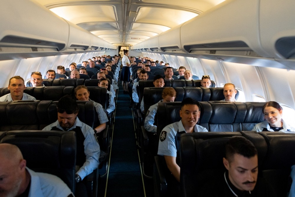 Members of the Australian Federal Police sit in a flight to the Solomon Islands to support...