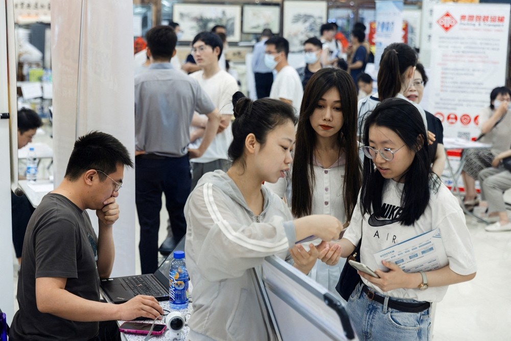 People attend a job fair in a mall in Beijing, China June 30, 2023. REUTERS/Thomas Pe...