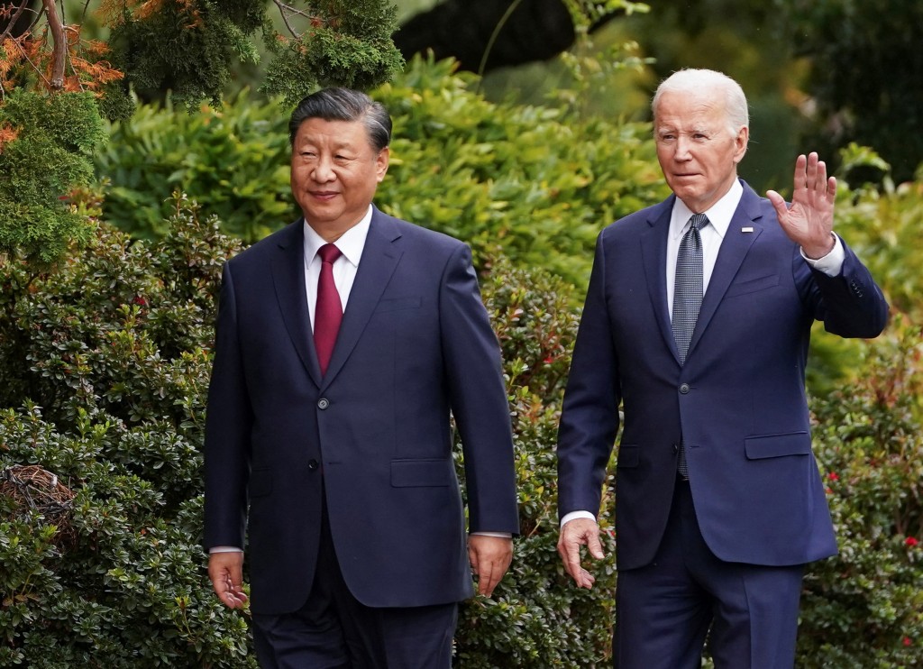 U.S. President Joe Biden waves as he walks with Chinese President Xi Jinping at Filoli estate on the sidelines of the Asia-Pacific Economic ...