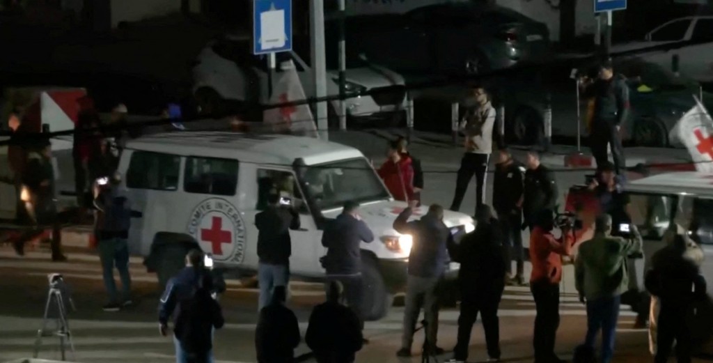 圖片顯示停火期間國際紅十字會車輛戴送以色列人質返國的畫面。（圖／路透社)
