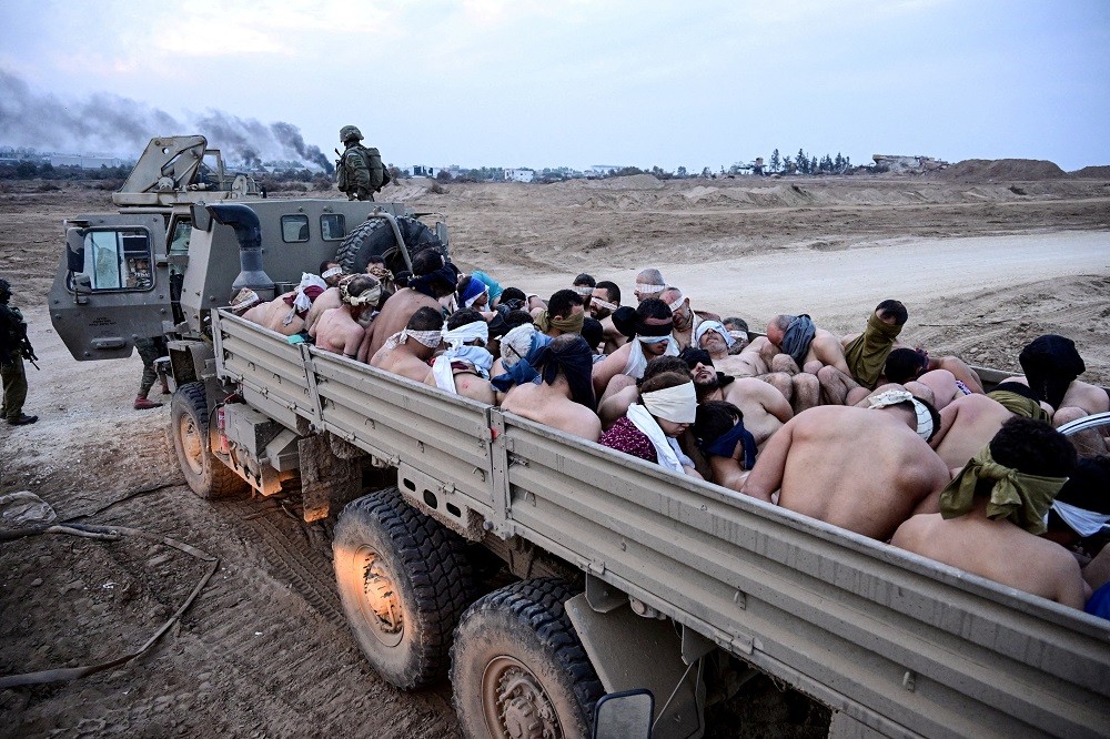 2023年12月8號，一群被俘虜的巴勒斯坦人光著上半身在以色列軍用卡車上，以色列聲稱這些人是哈瑪斯隊員（圖／路透社YOSSI ZELIGE...