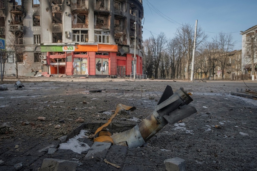2023年2月24日，烏克蘭前線城市巴赫姆特一輛被俄羅斯炸毀的建築物旁，一枚火箭的一部分掉落在地上（圖／路透社Alex Babenko）
