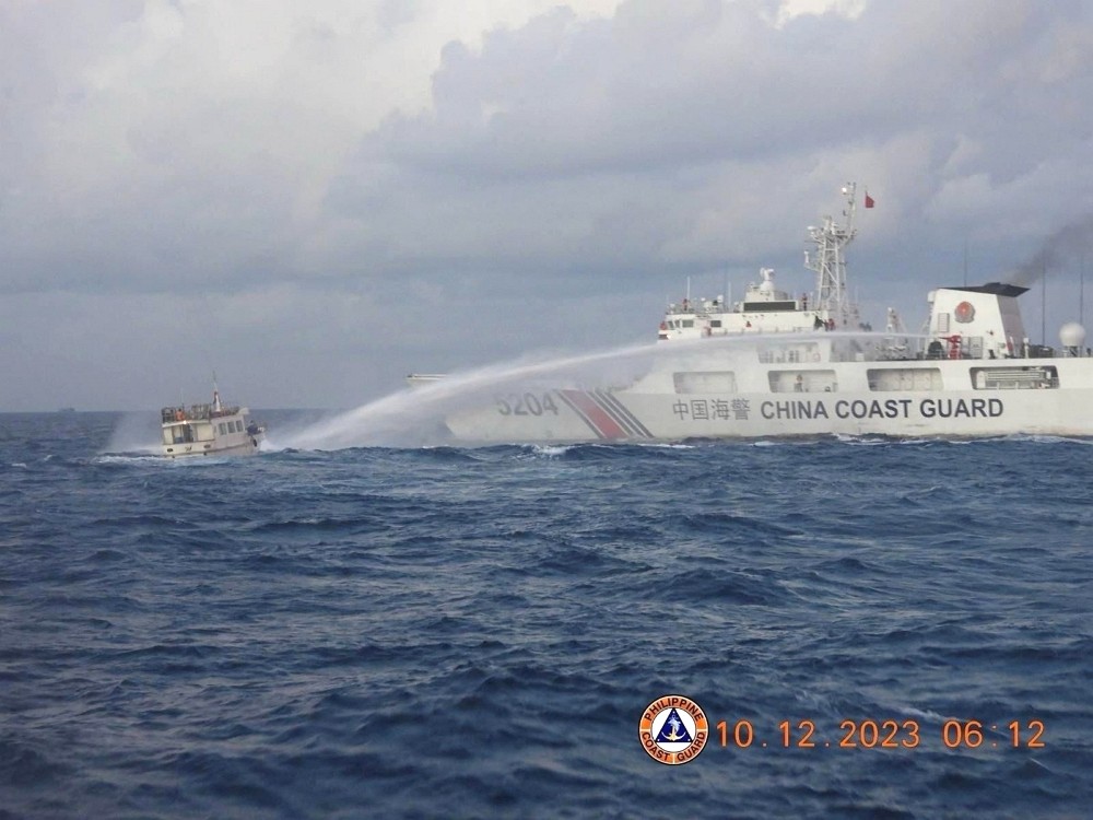 2023年12月10日，中國海警船用高壓水柱驅趕菲律賓補給船。（圖／路透社Philippine Coast Guard...