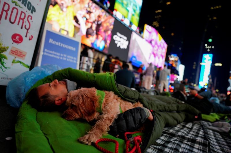 圖為帶著狗狗一起流浪街頭的美國遊民, 露宿於紐約時報廣場 (路透2023年11月16日照片/Adam Gray ) 

