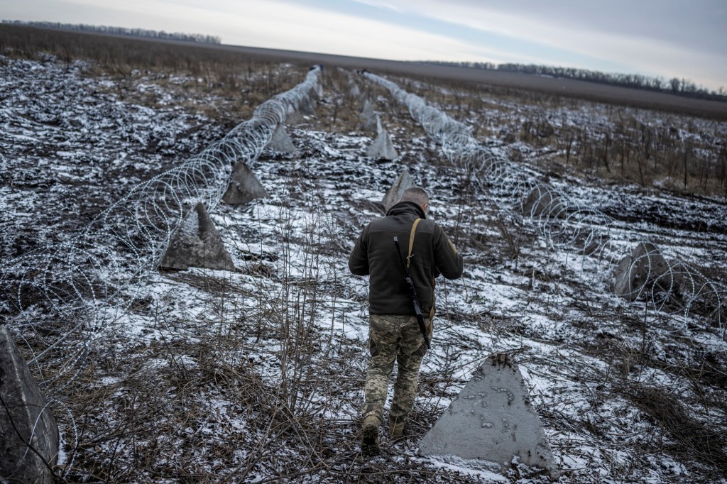 一名烏克蘭士兵 2023 年 12 月 25 日步行與俄接壤的哈爾基夫州，巡守交戰前線的畫面。 (圖片來源：路透社)
