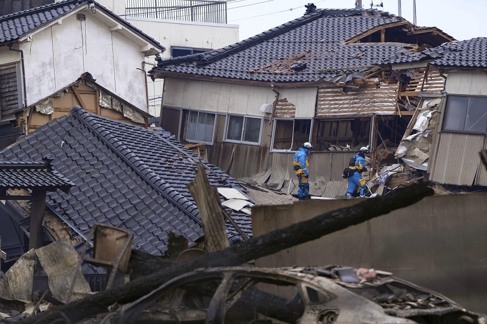 2024年1月2日，日本石川縣輪島市，救難人員在倒塌的房屋中搜救（圖／KYODO via 路透社）
