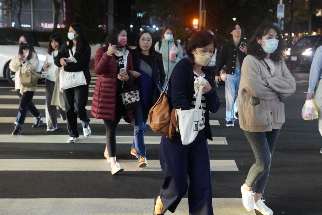 台北市信義區街頭民眾穿著保暖外套過馬路（圖／中央社）
