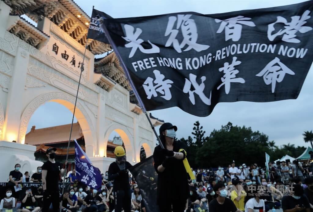 民眾在自由廣場高舉「光復香港，時代革命」旗幟。（圖／中央社）
