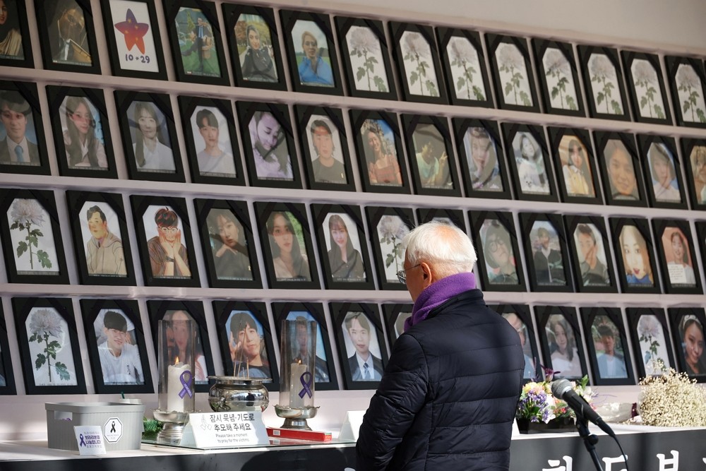 A man mourns at the memorial altar for victims before a press conference against the government’s decisi...