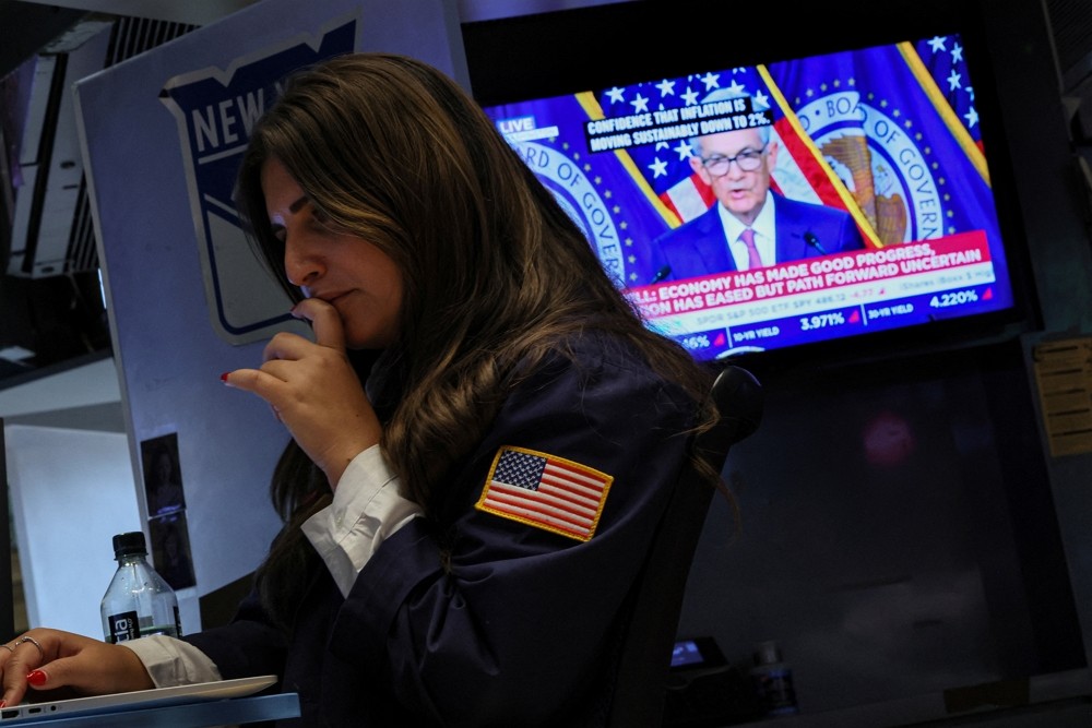A trader works, as a screen displays a news conference by Federal Reserve Board Chairman Jerome Powell following the Fed rate announcem...
