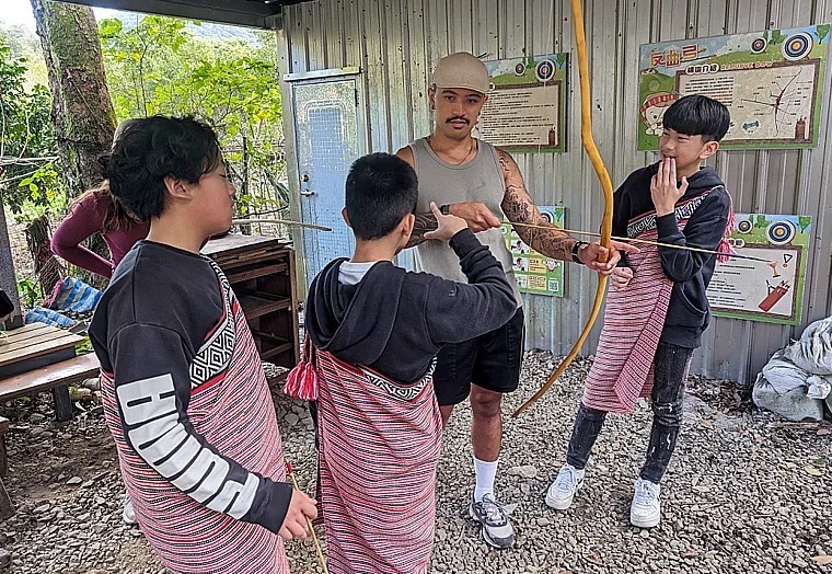 Fushan Elementary students practice archery with visitor from New Zealand. (New Taipei Department of Education photo)
