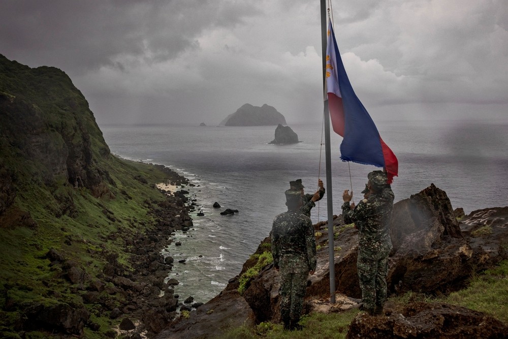 Filipino soldiers take part in a flag raising ceremony on Mavulis Island during a trip of the chief of staff of the Armed Forces of the Philippines, i...