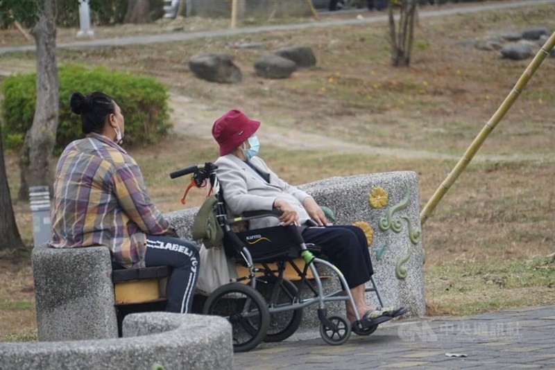 A migrant caregiver (left) at a Taipei park. 
