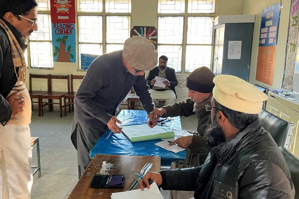 2024 年 2 月 8 日，一名巴基斯坦選民在調票所內進行身分驗證 （圖／路透社Ariba Shahid）
