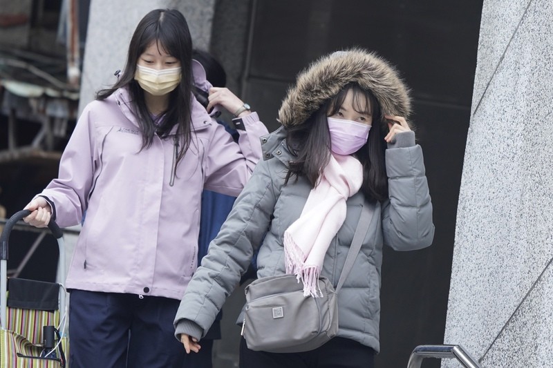 台北市民眾2月9日在雙連捷運站出口拉好外套禦寒（圖／中央社）
